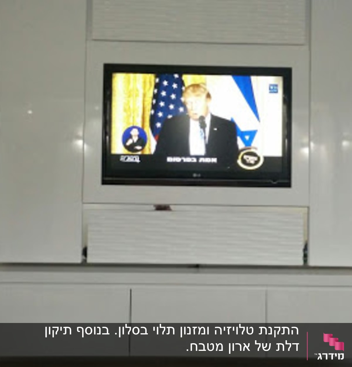 טלוויזיה תלויה על קיר עם מסגרת לבנה